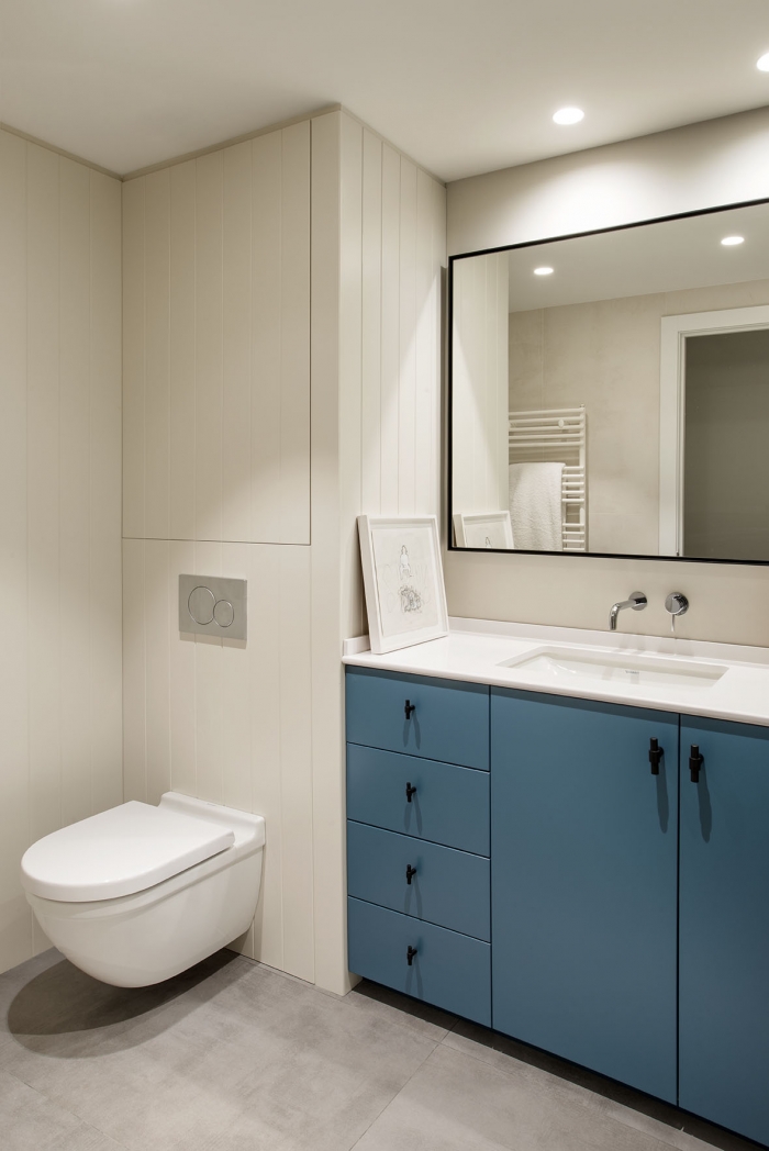 White bathroom with blue cabinet 