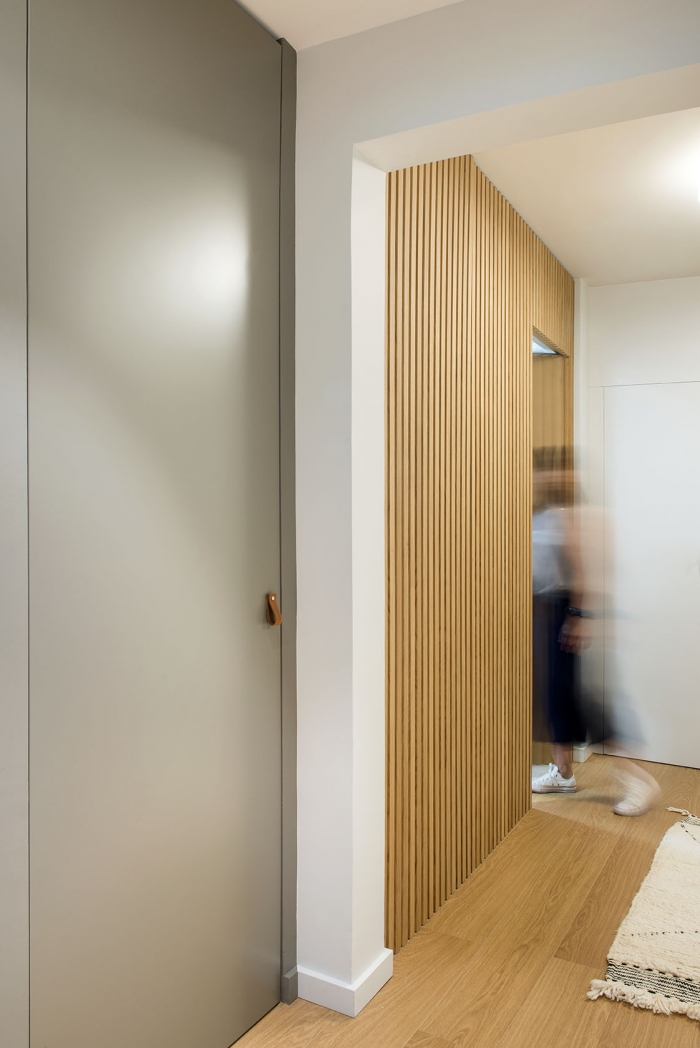 Panelado con listones de madera con puerta oculta 