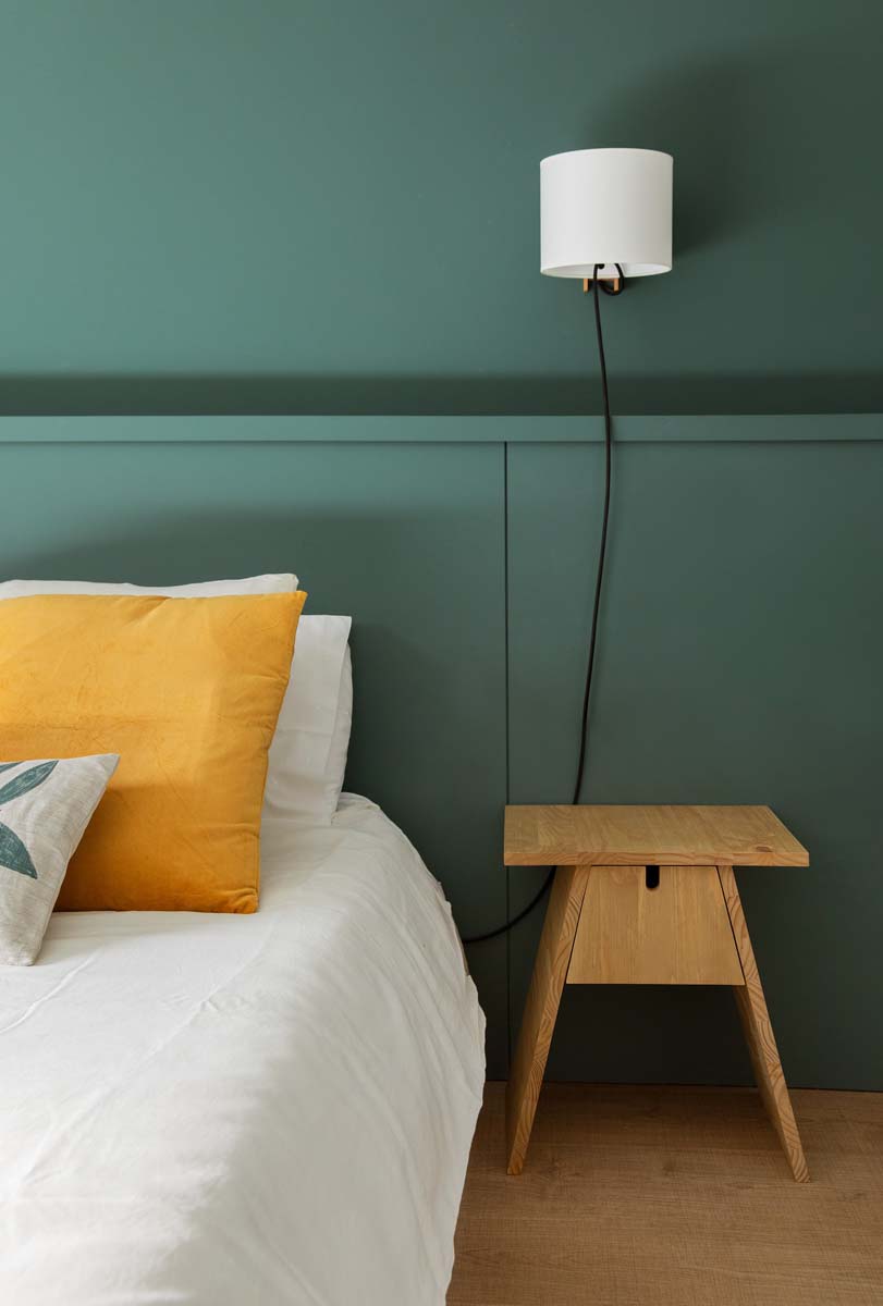 Habitación verde con mesita de madera | The Room Co